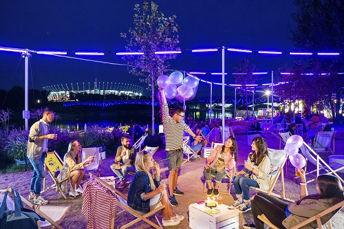 Gruppo di persone che si divertono durante una serata estiva lungo il fiume Vistola